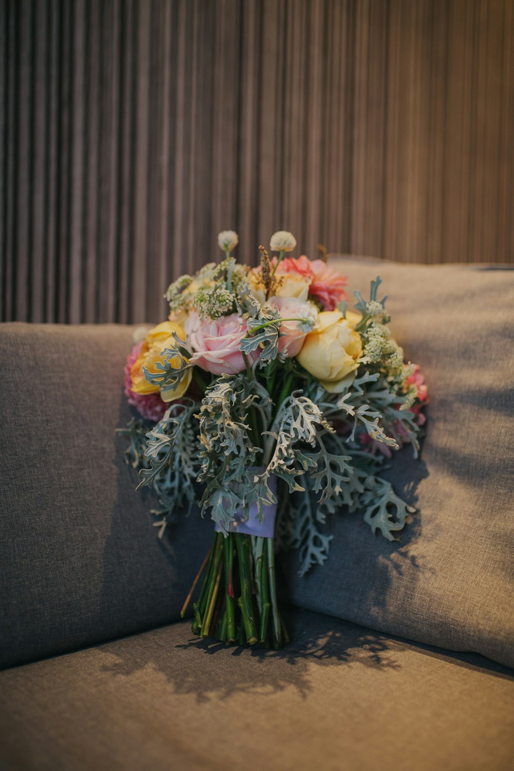 bouquet of rose flowers on gray sofa inside room