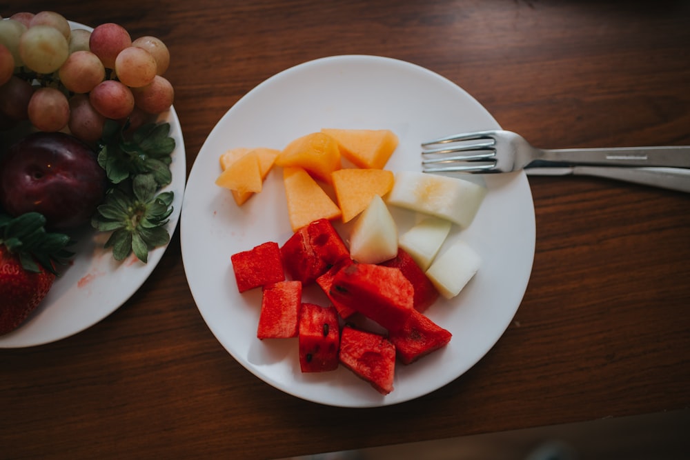 sliced watermelon and mango on plate with fork
