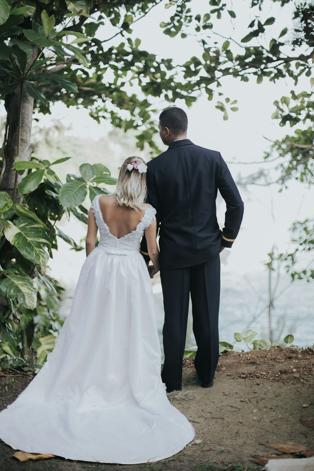 bride and groom holding hands under tree