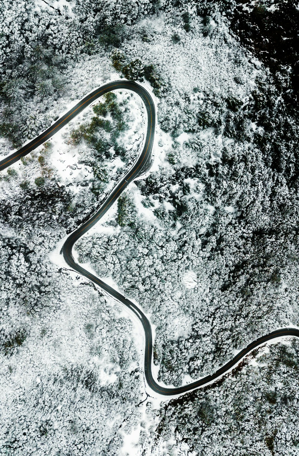 Eine kurvenreiche Straße inmitten eines schneebedeckten Feldes