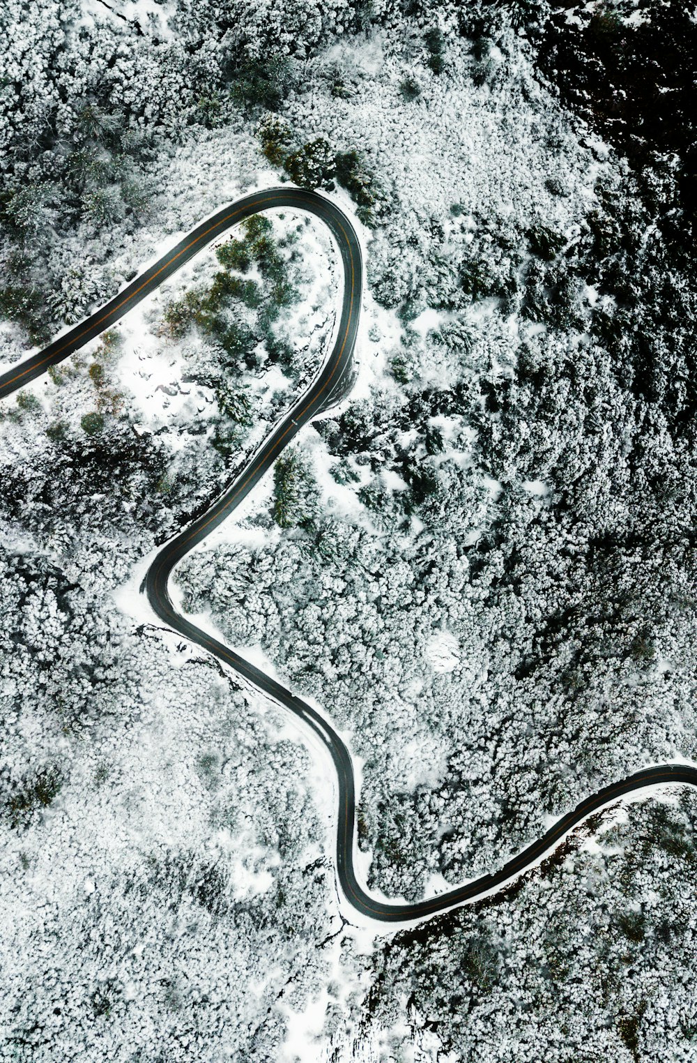 uma estrada sinuosa no meio de um campo coberto de neve