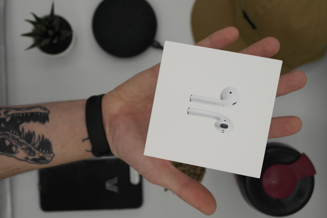 An employee unboxing a high-end tech gift like wireless earbuds - employee engagement gifts An employee unboxing a high-end tech gift like wireless earbuds - employee engagement gifts