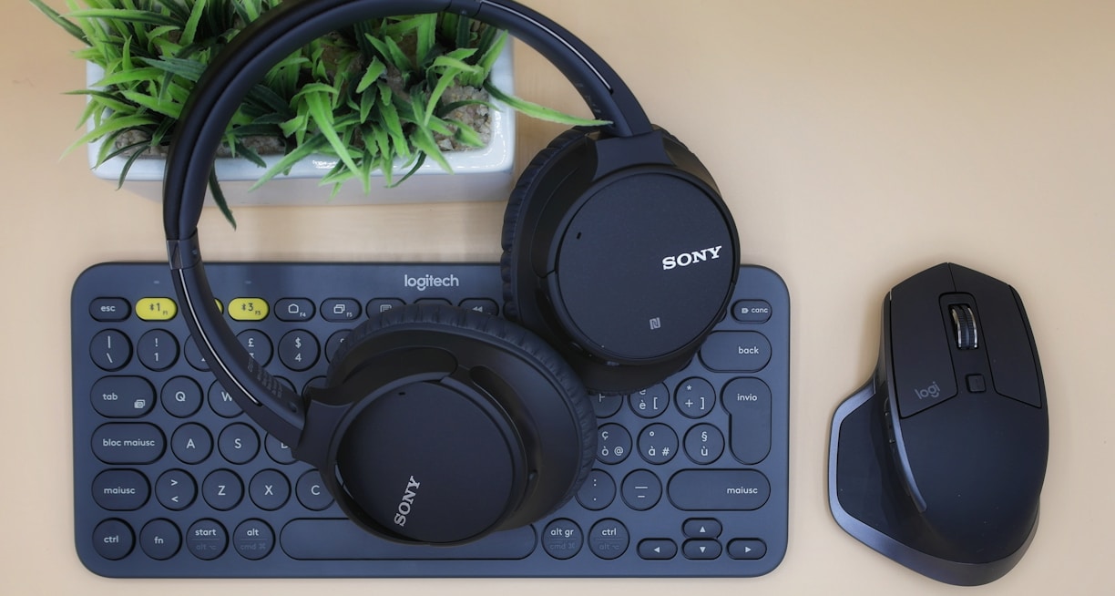 black Sony wireless headphones on black computer keyboard