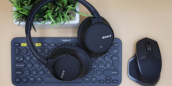 black Sony wireless headphones on black computer keyboard