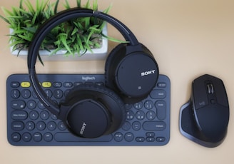 black Sony wireless headphones on black computer keyboard