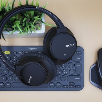 black Sony wireless headphones on black computer keyboard