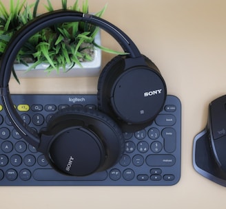 black Sony wireless headphones on black computer keyboard