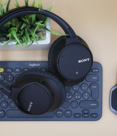 black Sony wireless headphones on black computer keyboard