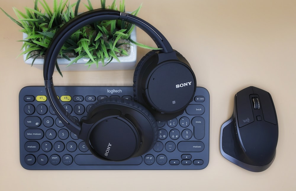 black Sony wireless headphones on black computer keyboard