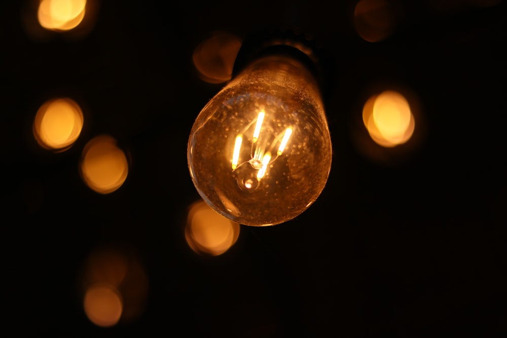 bokeh lights photography of filament light bulb at night