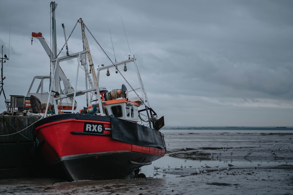 two abandoned black and red boat on shore