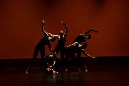 A group of students performing an energetic urban dance routine on stage.