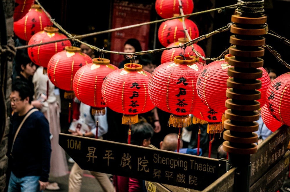 red paper lanterns hanging on the street beside street post