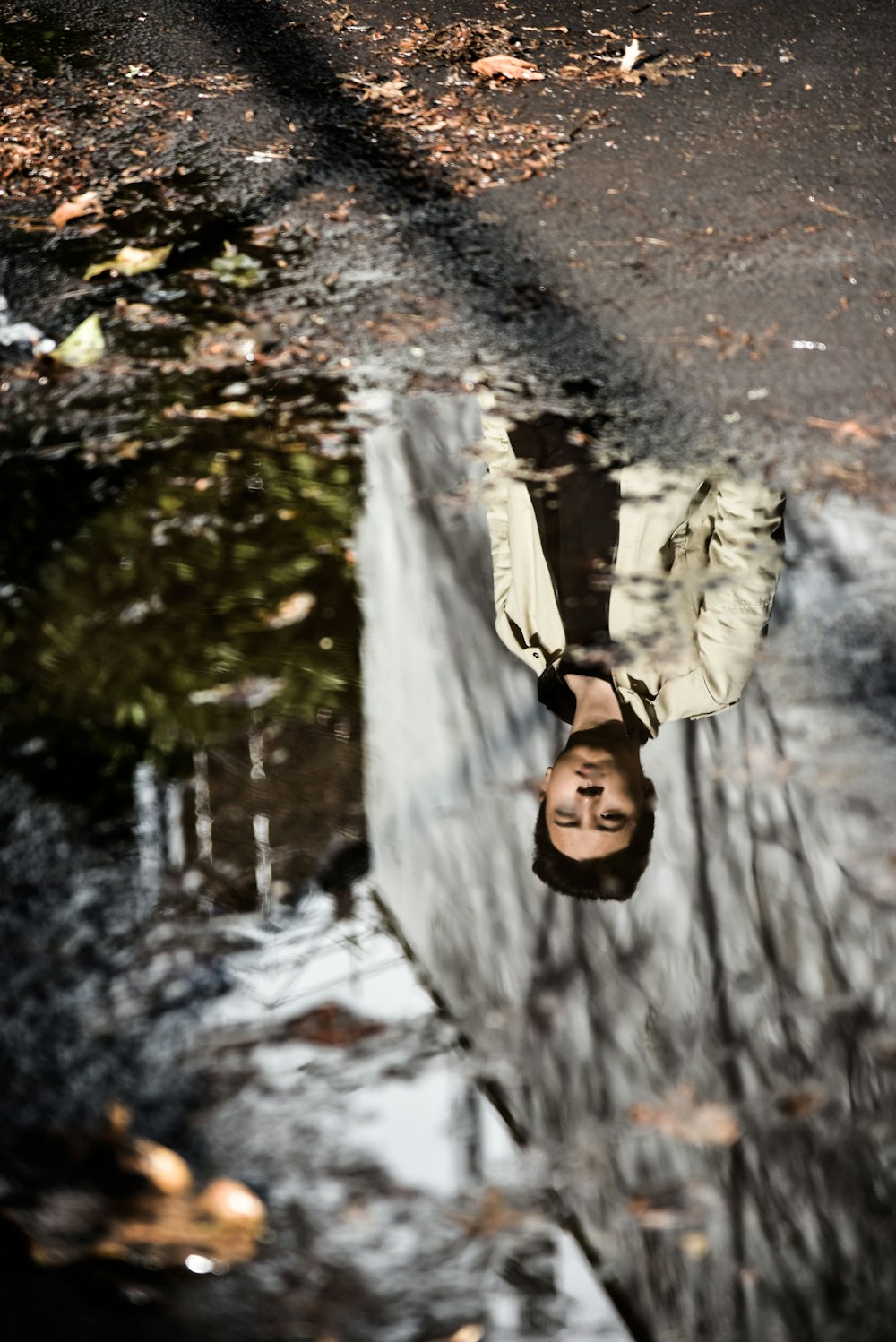 selective focus photography of reflection of man wearing gray jacket