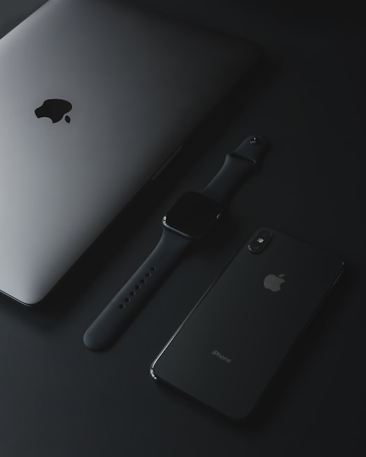 Sleek display of premium Apple accessories including cases and chargers on a black glass surface with subtle blur