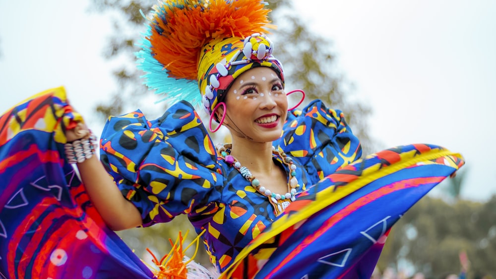 smiling woman wearing multicolored dress dancing outdoor during daytime