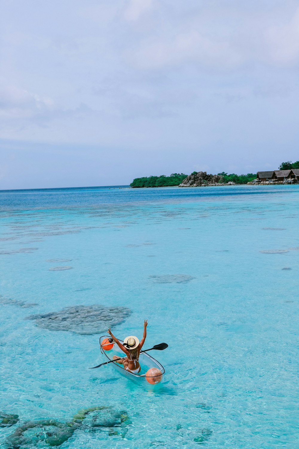 woman at shallow sea water riding transparent boat