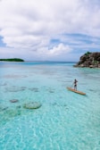 A paddleboarder gliding smoothly across crystal-clear turquoise water.