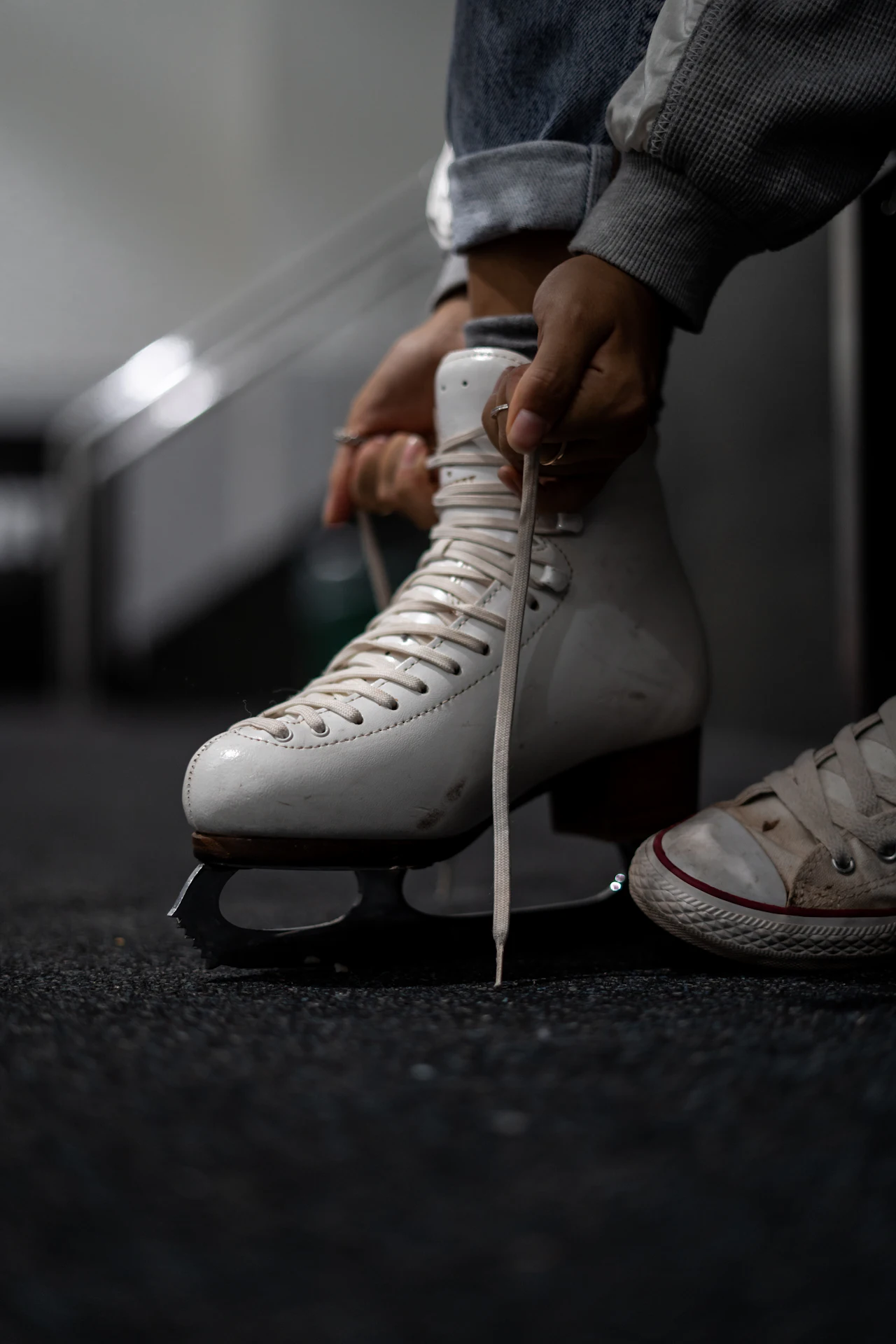 A close-up of white figure skating boots and blades