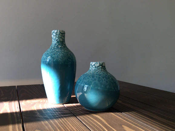 Close-up of a handmade stoneware vase with vibrant glaze colors on a wooden table