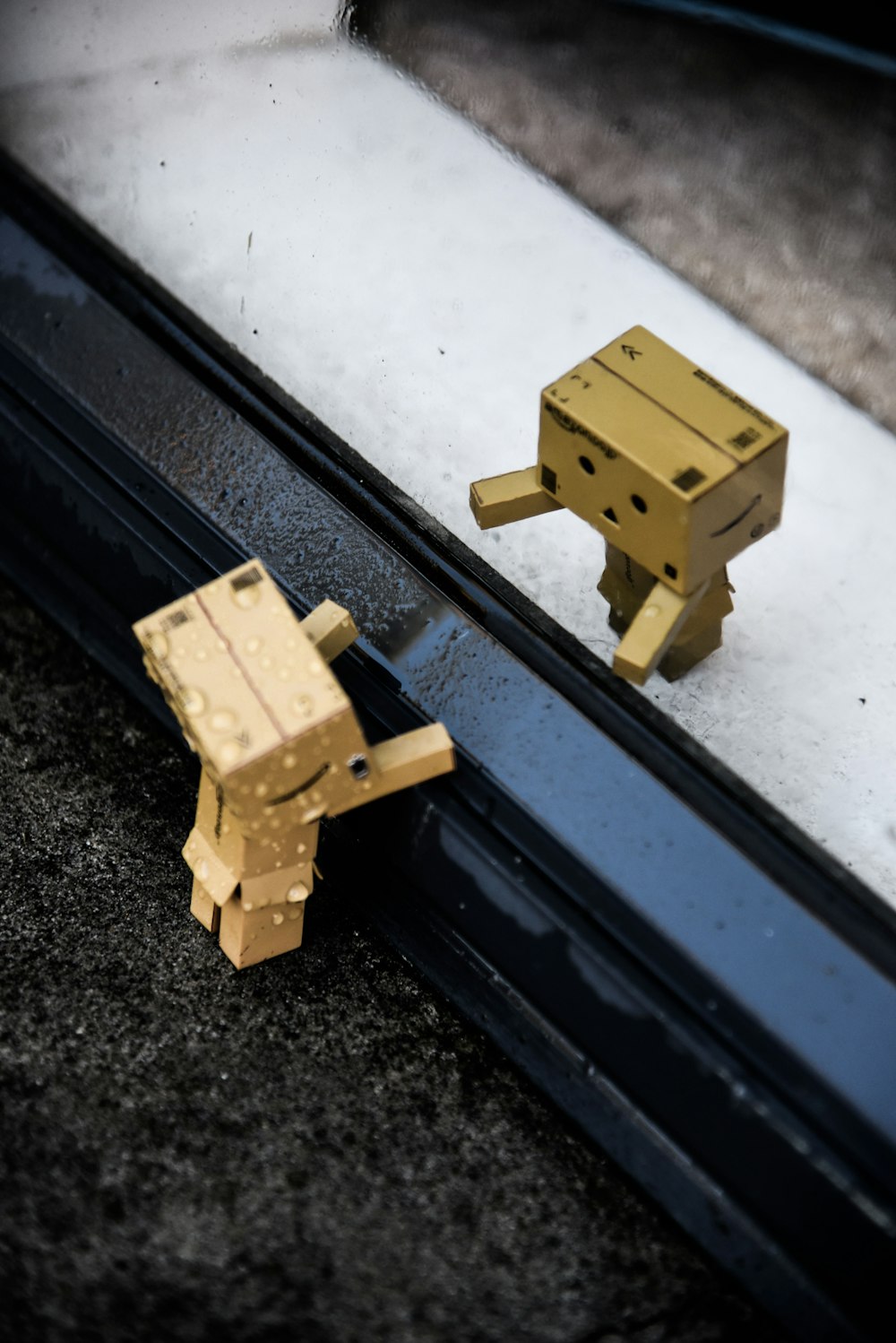 a pair of wooden toys sitting on top of a window sill