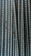 Close-up of stacked FE 500 grade TMT bars with a textured steel surface.
