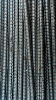 A construction worker inspecting rebar on a job site.