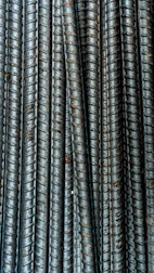 Close-up of hands inspecting high-quality steel bars on site.