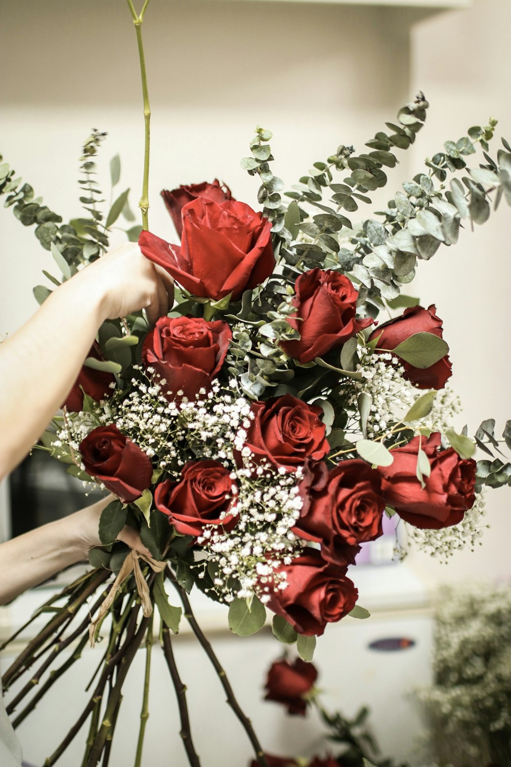 person holding red rose bouquet