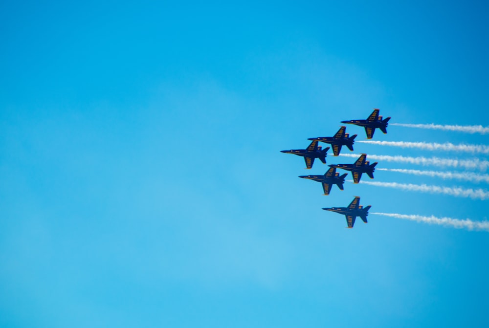 seis caças pretos fazendo show aéreo durante o dia