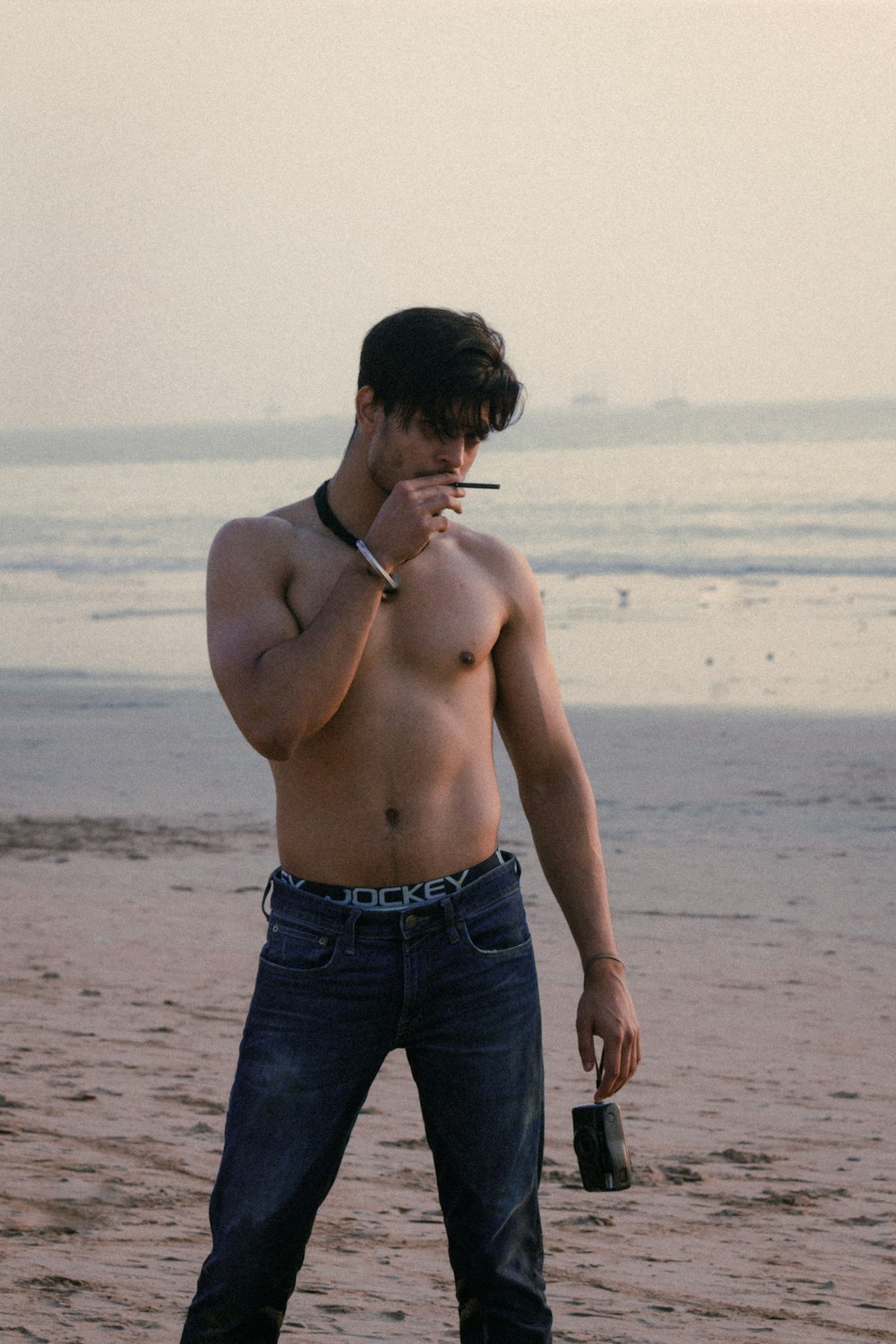 Hombre en topless fumando cerca de bach
