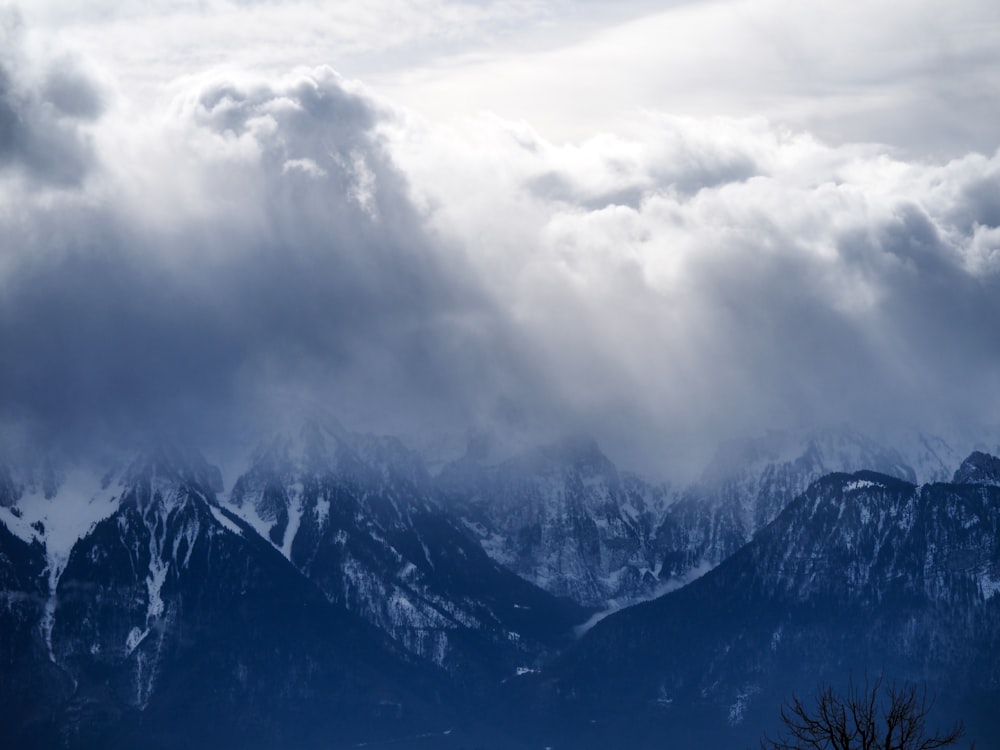 white clouds above snow-capped mountain