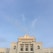An elegant white building with classical architectural features, adorned with columns and decorative elements, topped with signage that reads 'EMPERADOR'. The sky is clear and blue, providing a serene backdrop.