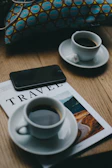A phone and a cup of coffee on a table, symbolizing quick and easy booking via call or WhatsApp.