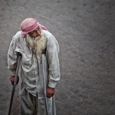 An elderly pilgrim receiving gentle assistance during a reflective moment