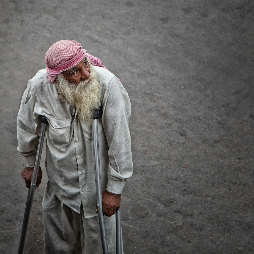 man in dress shirt using axilliary crutches