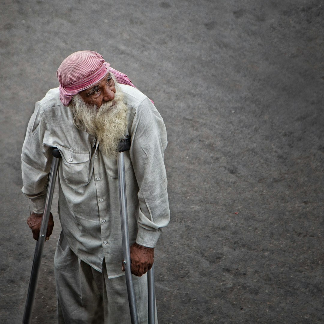 man in dress shirt using axilliary crutches