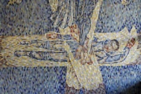A mosaic artwork depicts an abstract scene with intricate patterns and vivid colors. It features a figure lying down, possibly enveloped or protected. The mosaic is composed of small, colorful tiles arranged to create a dynamic interplay of shapes and lines.