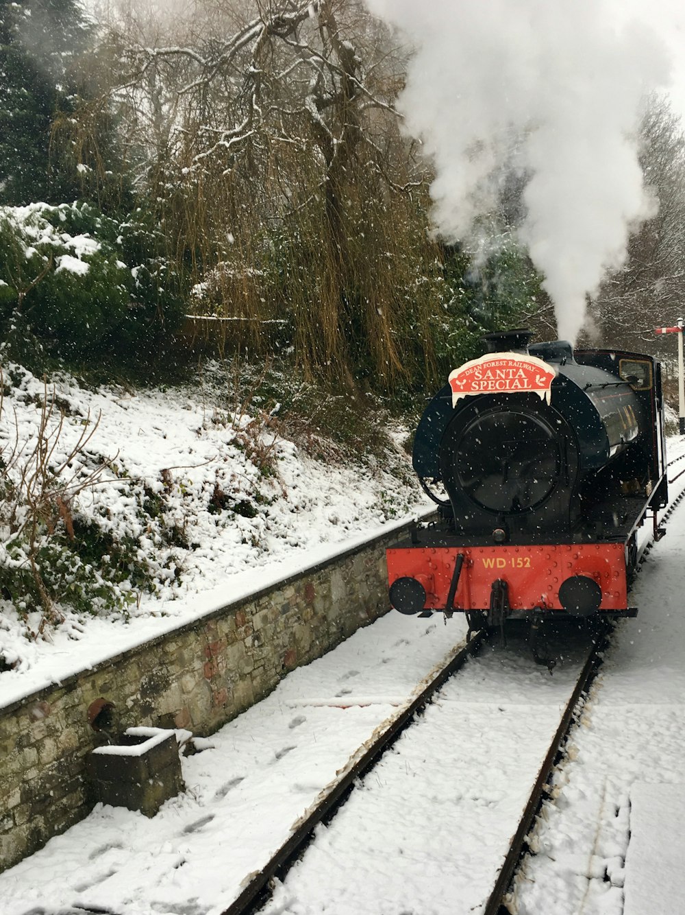 black and red train on snowy rails