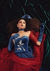 woman wearing blue sweetheart dress with red scarf