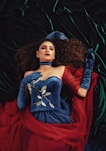 woman wearing blue sweetheart dress with red scarf