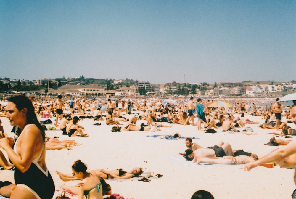 pessoas tomando sol na praia durante o dia