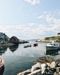 canoe boat on body of water under blue sky