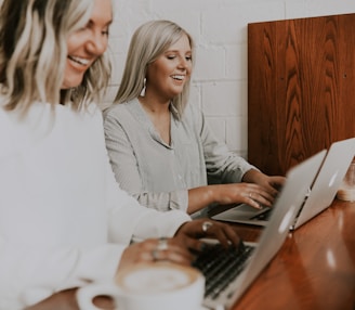 two women using laptops