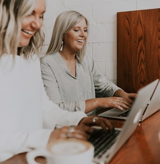 two women using laptops