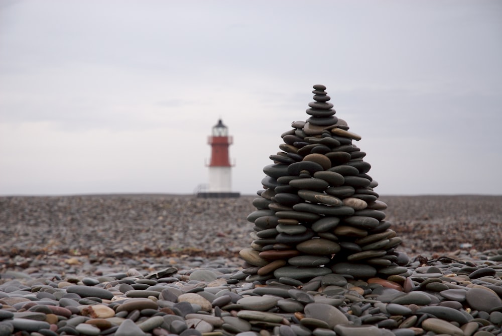 灯台の背景を持つストックされた石の選択焦点写真