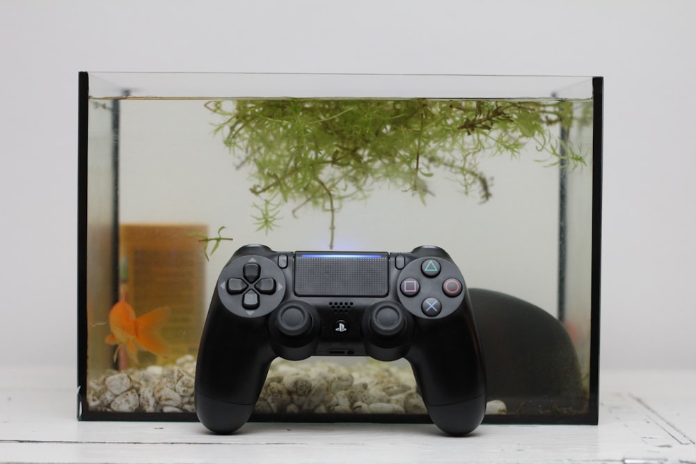 a video game controller sitting in front of a fish tank