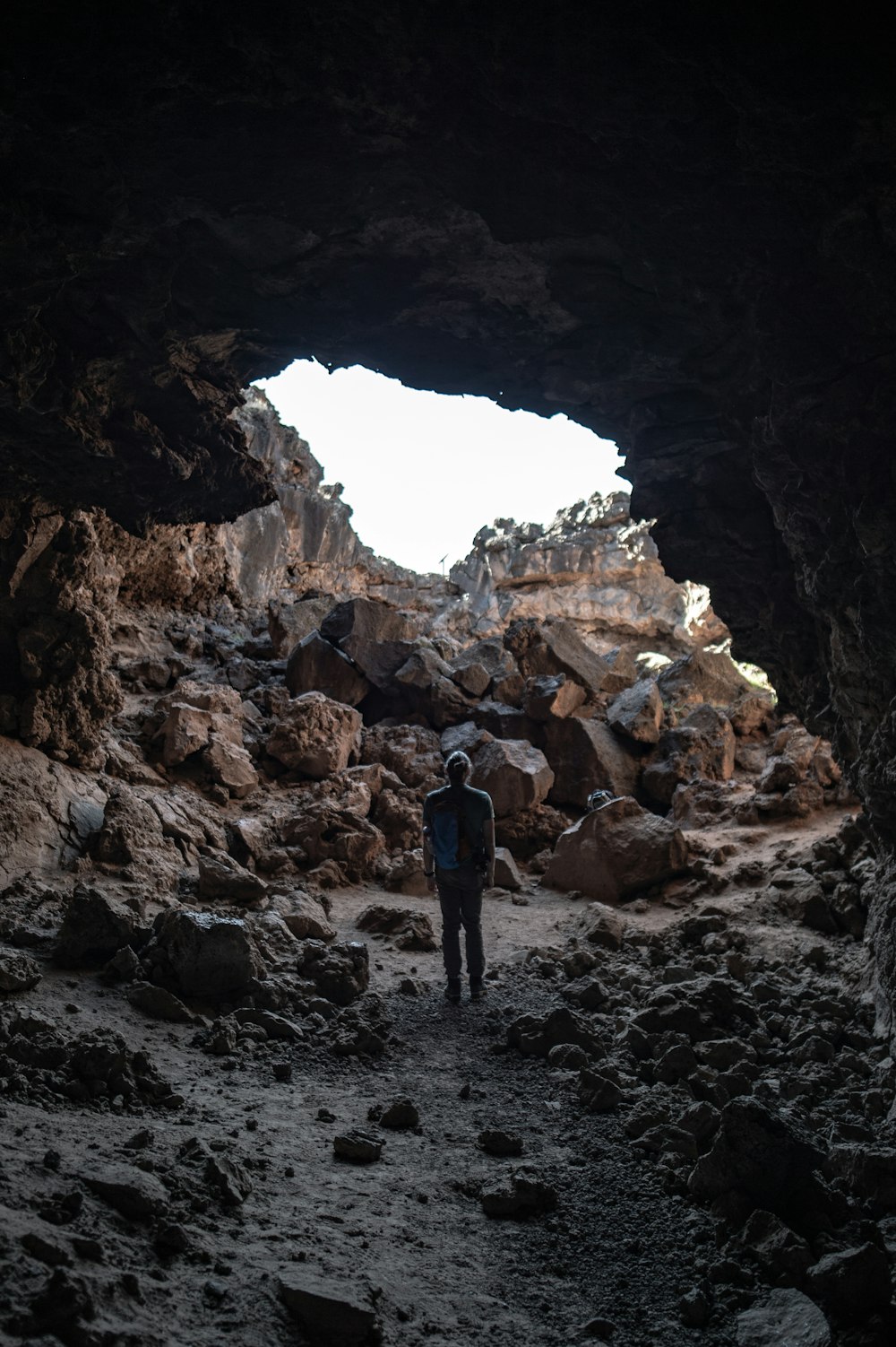 focus photography of man standing on cave