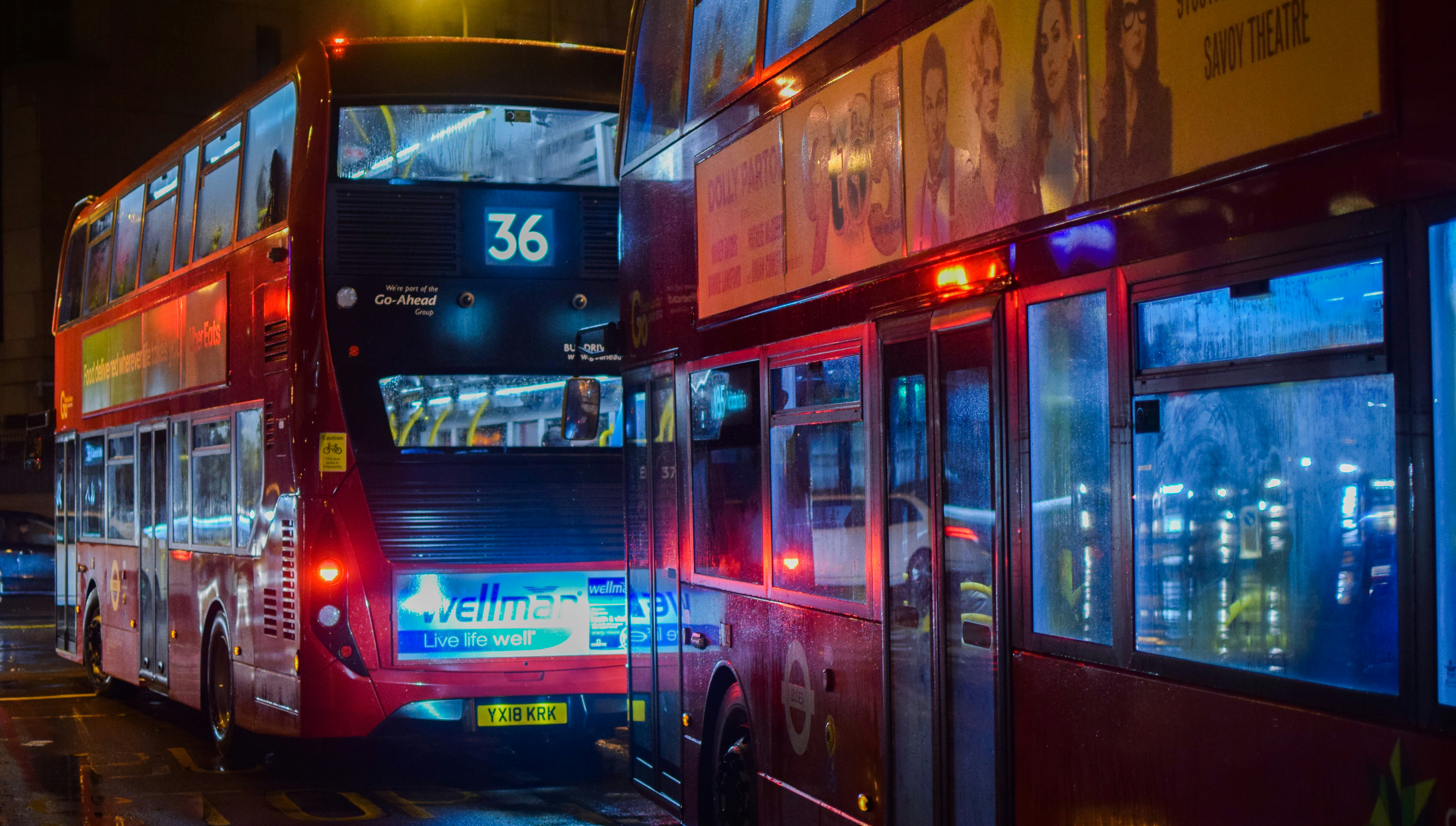 two red buses on road at night, 