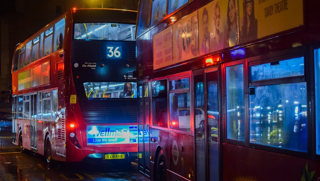 two red buses on road at night,